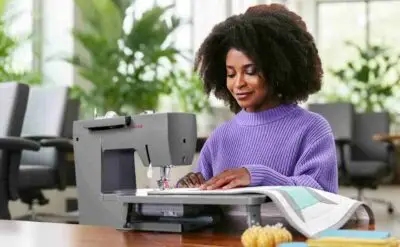 Mechanical extension table for SINGER Heavy Duty sewing machines, stable work surface with adjustable support legs.